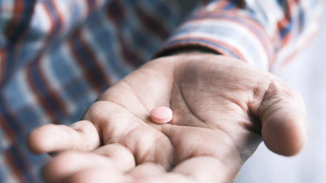 Close up of man hand holding pills with copy space .