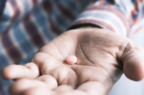 Close up of man hand holding pills with copy space .