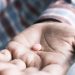 Close up of man hand holding pills with copy space .