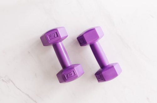Top view of purple unit cast dumbbell of seven kilo weight placed on white marble surface