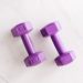 Top view of purple unit cast dumbbell of seven kilo weight placed on white marble surface